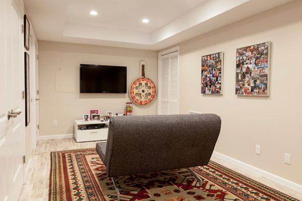 Small-basement-TV-room-with-a-lovely-rug-and-a-small-sofa