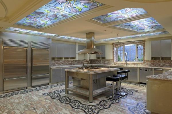 the-kitchen-sits-under-stained-glass-skylights-it-has-plenty-of-custom-touches-like-stone-flooring-two-steel-refrigerators-and-a-center-island-mounted-range-and-hood