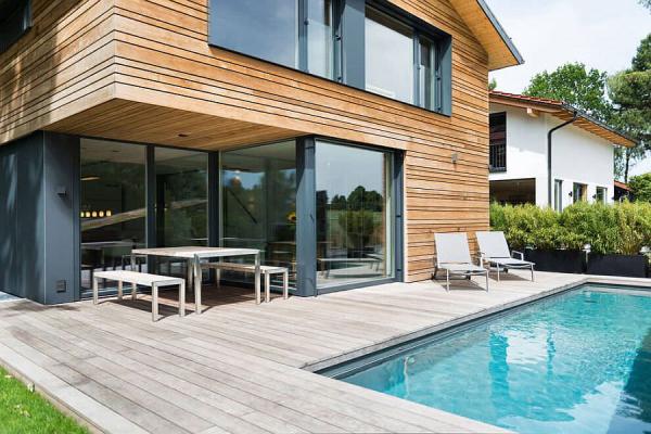 Glass-doors-connect-the-living-area-with-the-wooden-deck-and-pool-outside
