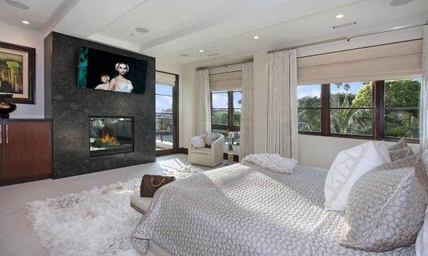 Modern-bedroom-with-fireplace-and-tv-above