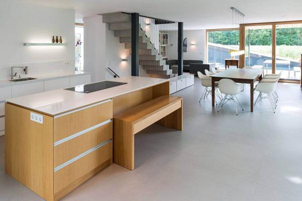 Wooden-kitchen-island-with-a-stine-worktop-and-a-wooden-becnh-for-breakfast-bar