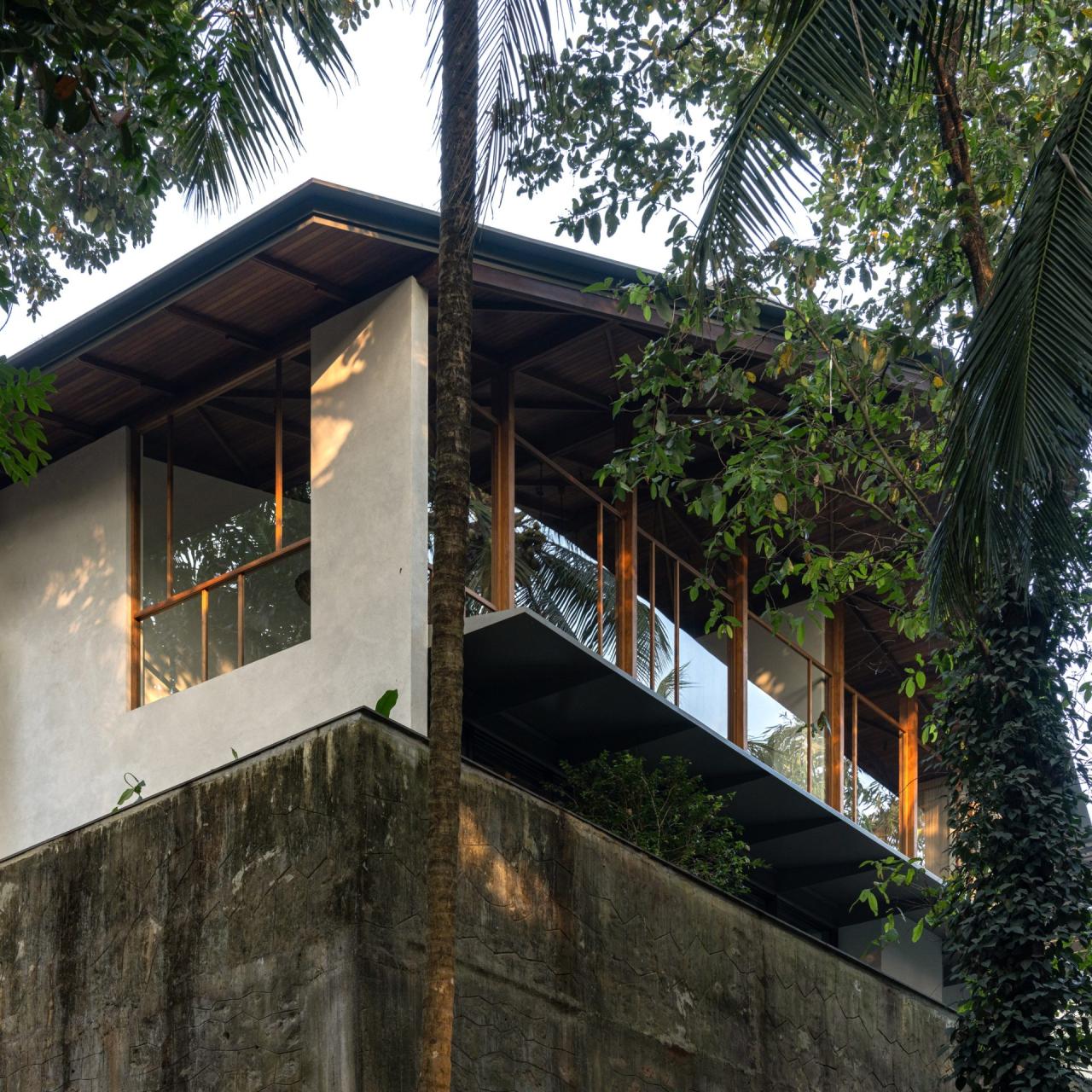 Interior cu tavan inalt, grinzi din lemn de cocos expuse si lumina naturala difuza — foto Thought Parallels Architecture / Dezeen