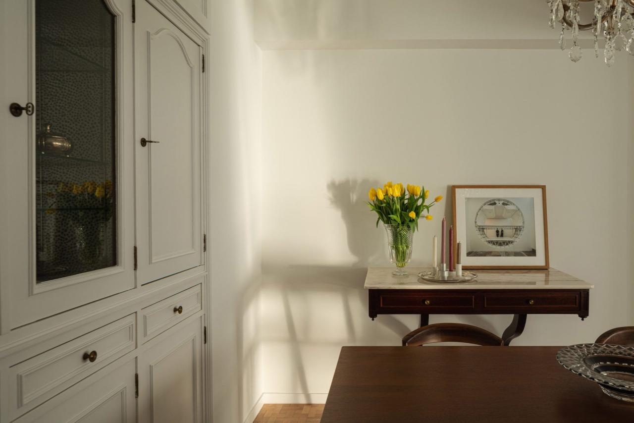 Detaliu zona dining cu vitrina alba si consola cu lalele galbene