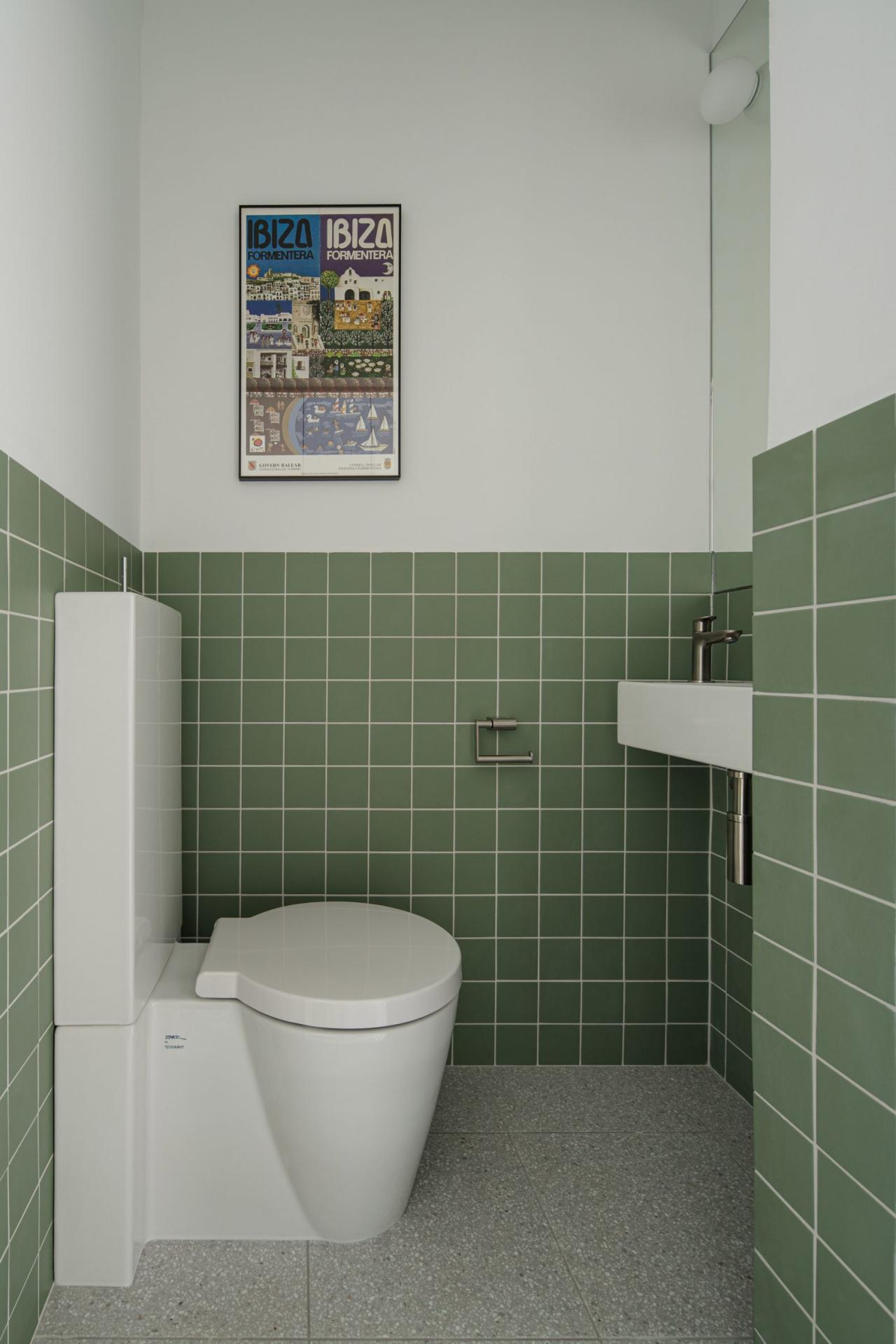 Toaleta de serviciu cu faianta verde-sage si poster Ibiza