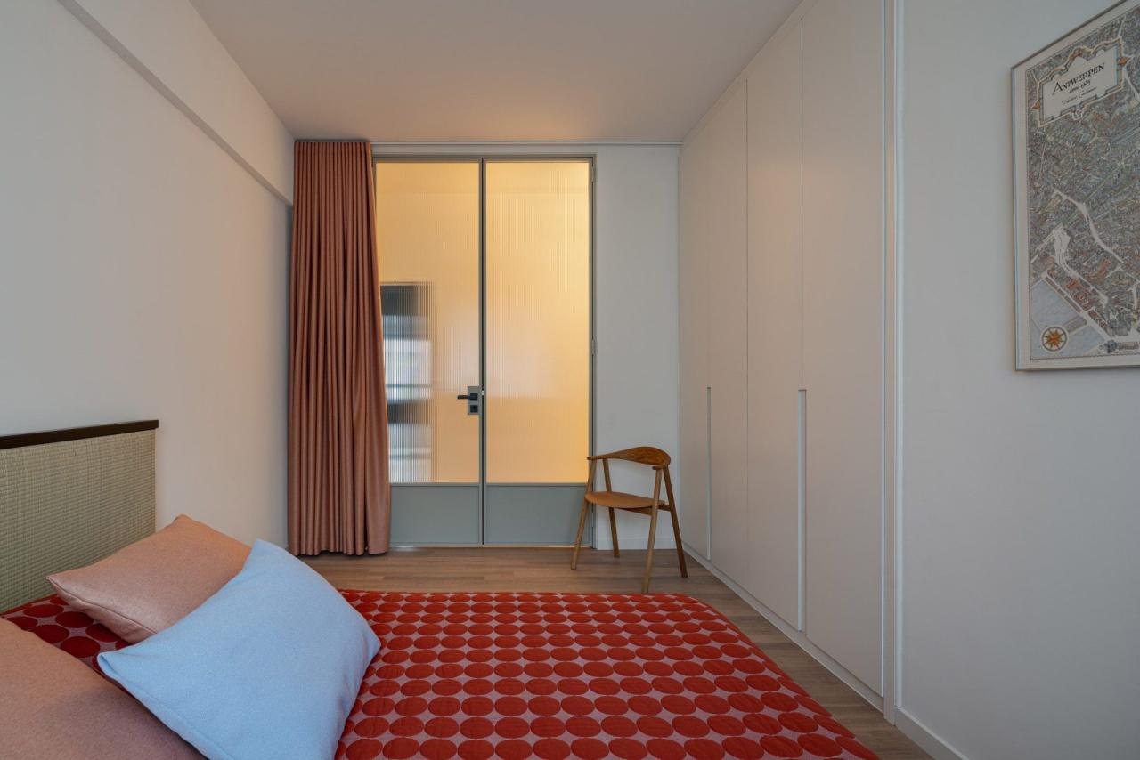 Dormitor cu cuvertura rosie cu buline si usa din sticla canelata