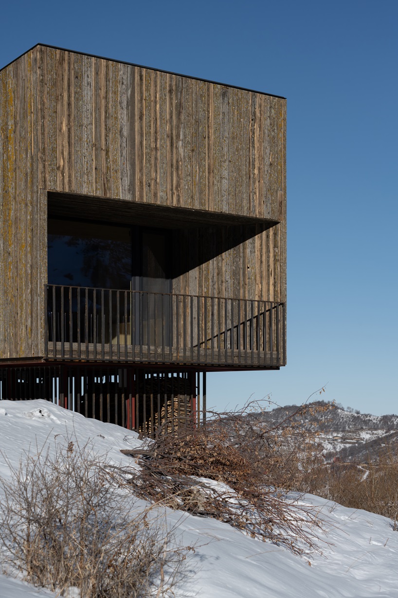 Detaliu fatada cabana AUM cu sipci verticale din lemn de larice recuperat si balcon metalic
