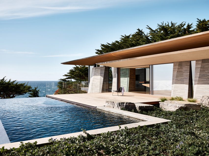 Piscina infinity alaturata terasei si casei cu pereti din calcar si acoperis subtire din lemn