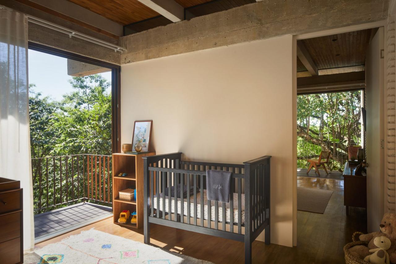 Camera copilului cu patut gri, rafturi din lemn si usi glisante spre terasa cu vegetatie tropicala – foto Thibault Cartier / Dezeen