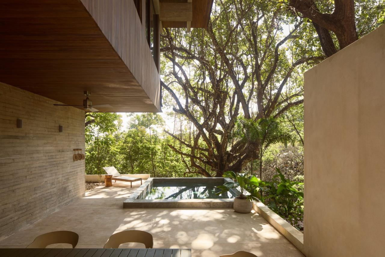 Terasa acoperita cu zona de relaxare, sezlong din lemn si piscina cu vedere spre padurea tropicala – foto Thibault Cartier / Dezeen