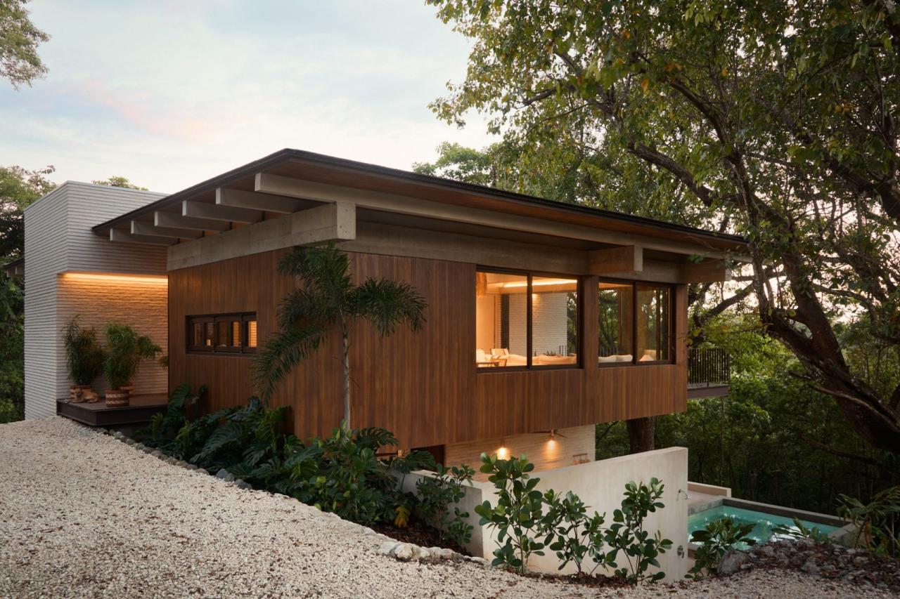 Fatada principala a casei Tres Pochotes la apus, cu fatada din lemn, ferestre panoramice si piscina – foto Thibault Cartier / Dezeen