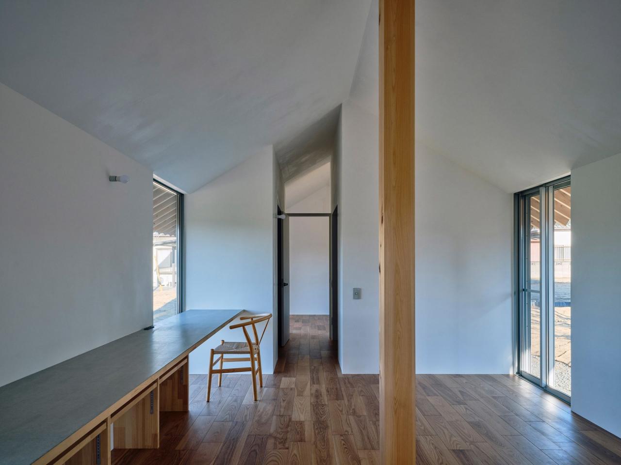 An Unfinished House - ferestre verticale cu vedere spre campurile agricole