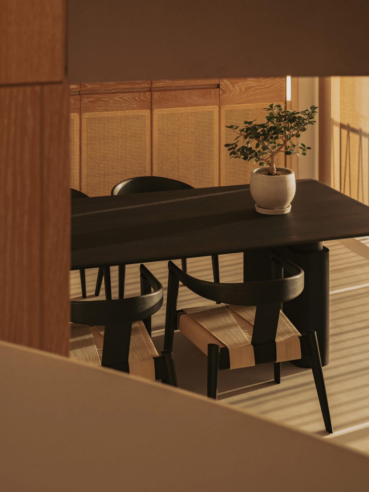 Zona de dining Lulla House cu masa neagra si scaune din ratan