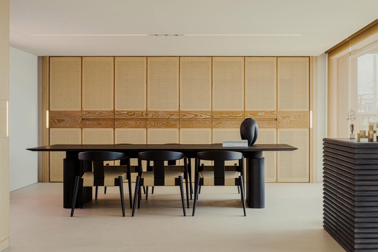 Zona de dining Lulla House cu masa neagra si perete din ratan