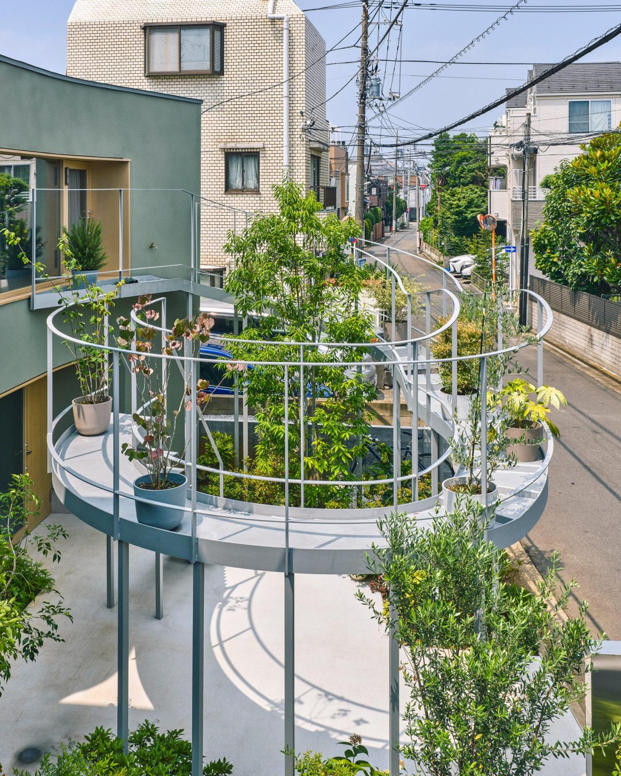 Terasa metalica Kazari Garden cu plante in ghivece, ridicata pe stilpi in fata ferestrei mari de la etaj — foto Takuya Seki / HOAA