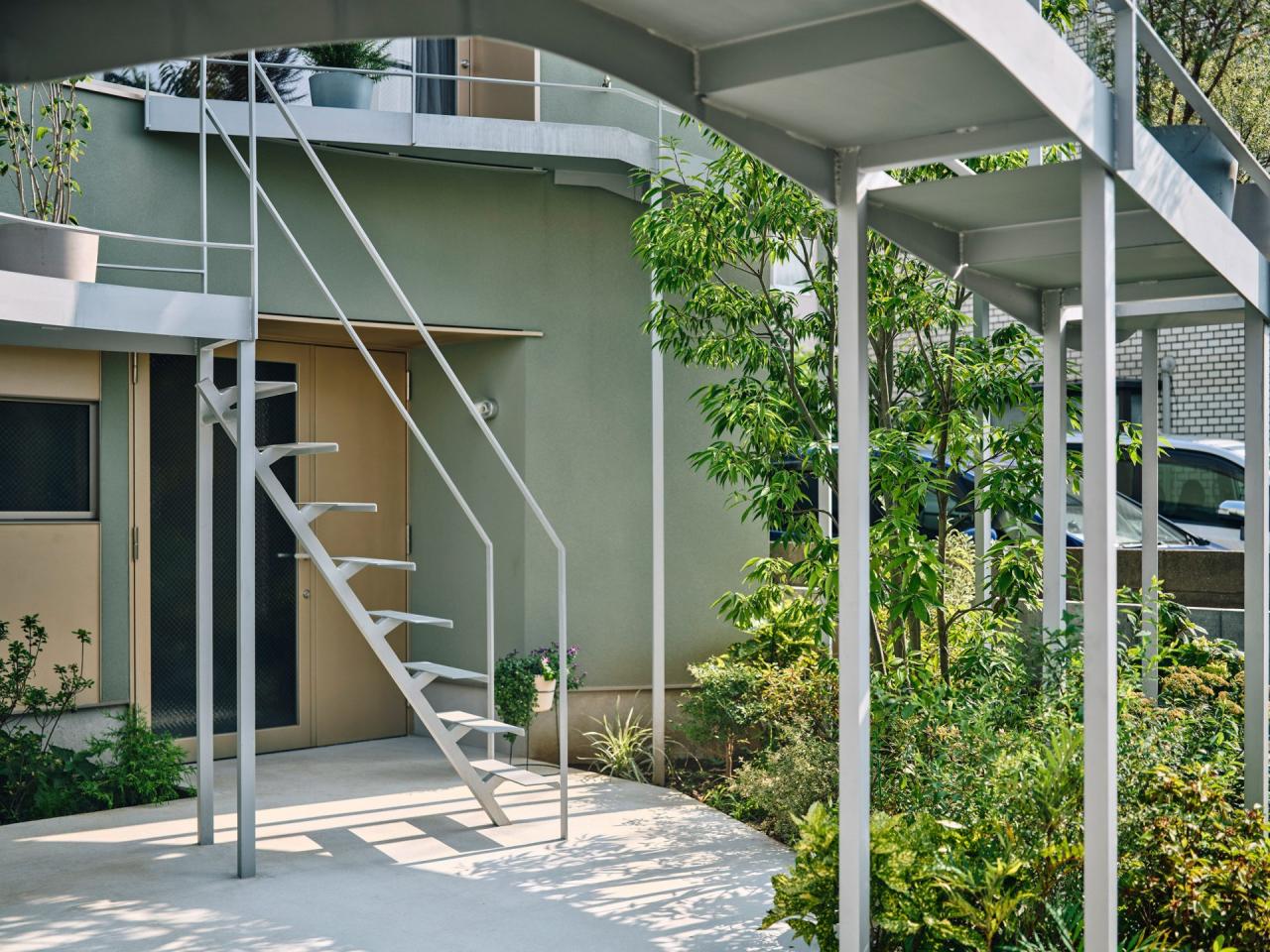 Vedere laterala a fatadei cu terasa circulara si scara de acces integrata in structura metalica — foto Takuya Seki / HOAA