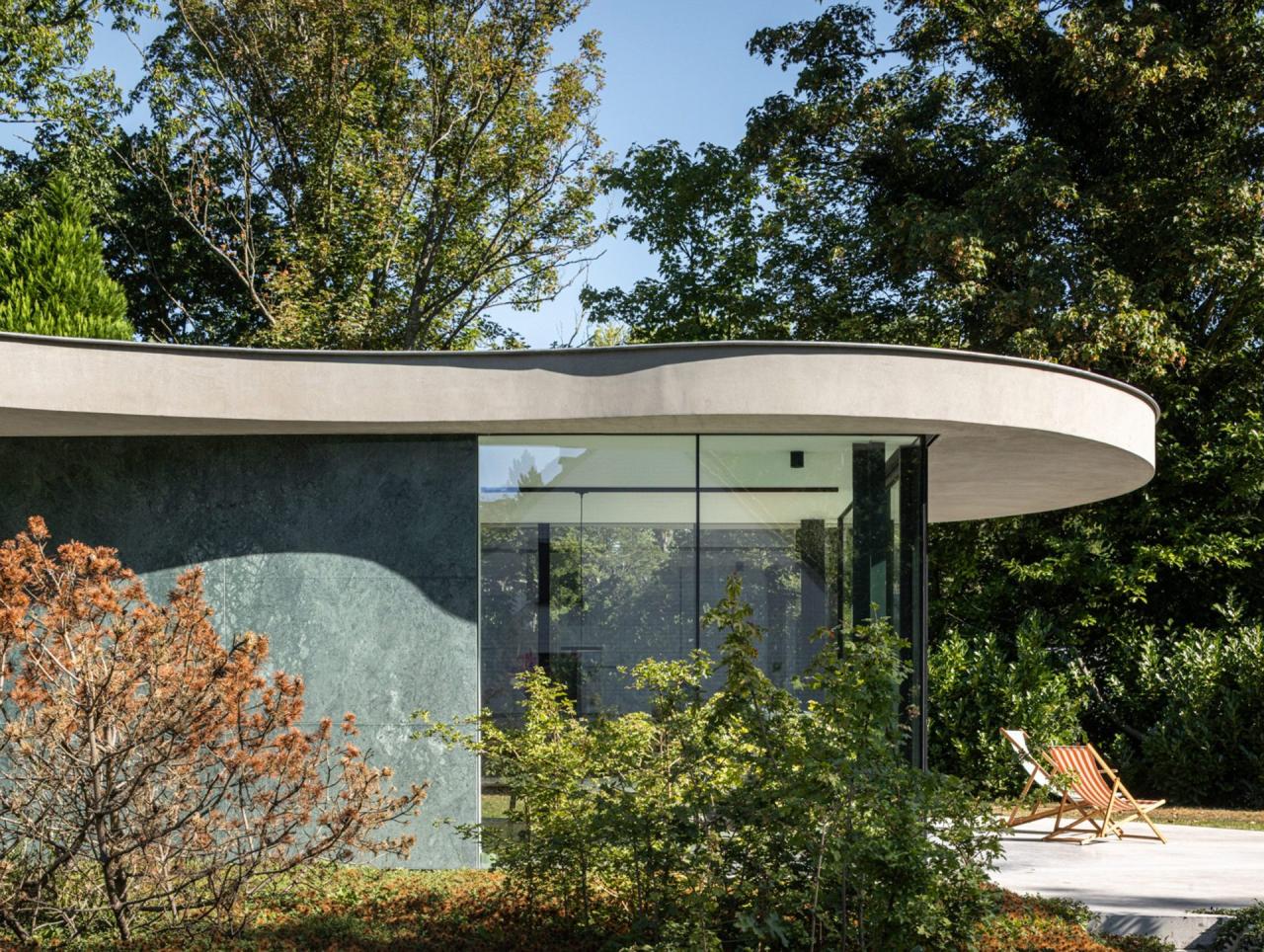 Insula de bucătărie din oțel inoxidabil — piesa centrală a spațiului de zi, cu vedere spre grădină