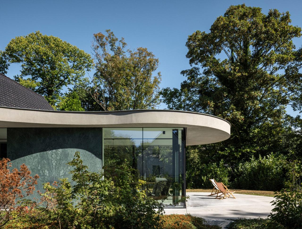 Conexiunea vizuală dintre interior și grădina matură — ușile glisante de sticlă se deschid complet