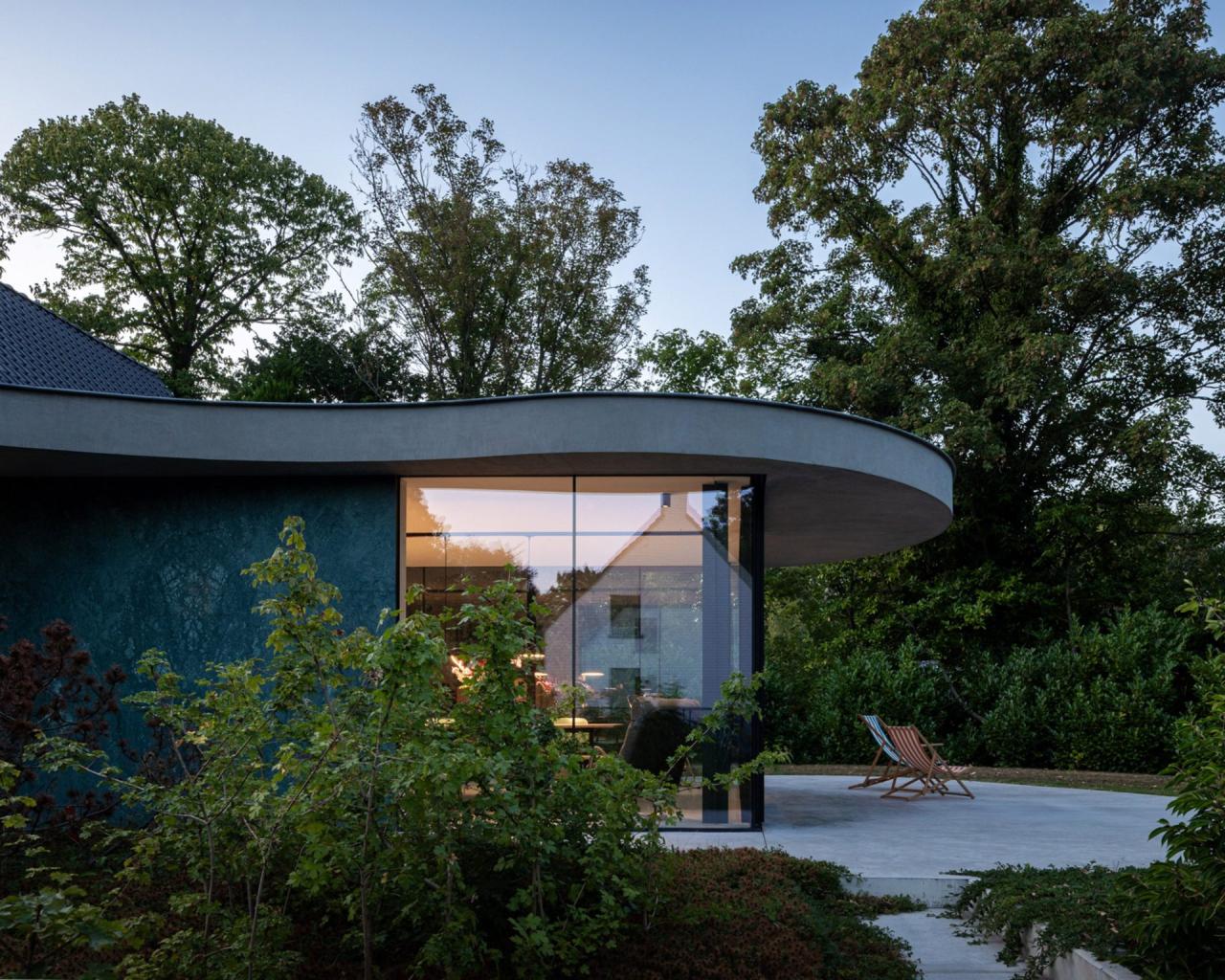 Zona de dining cu vedere spre grădină — scaunele de designer și masa din lemn masiv completează interiorul