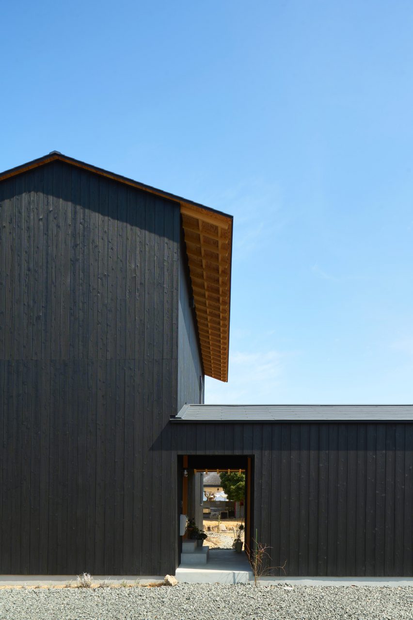 Intrarea în casă — culoarul acoperit care sparge monotonia fațadei oarbe, singurul semn de viață spre stradă