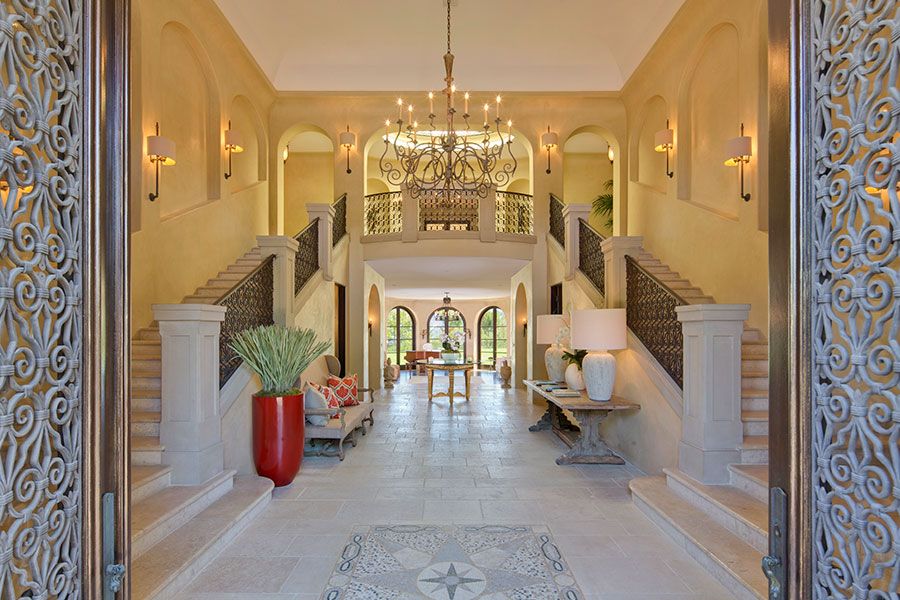 Holul de intrare cu doua scari simetrice din marmura, balustrade din fier forjat si lustre din bronz, usi sculptate