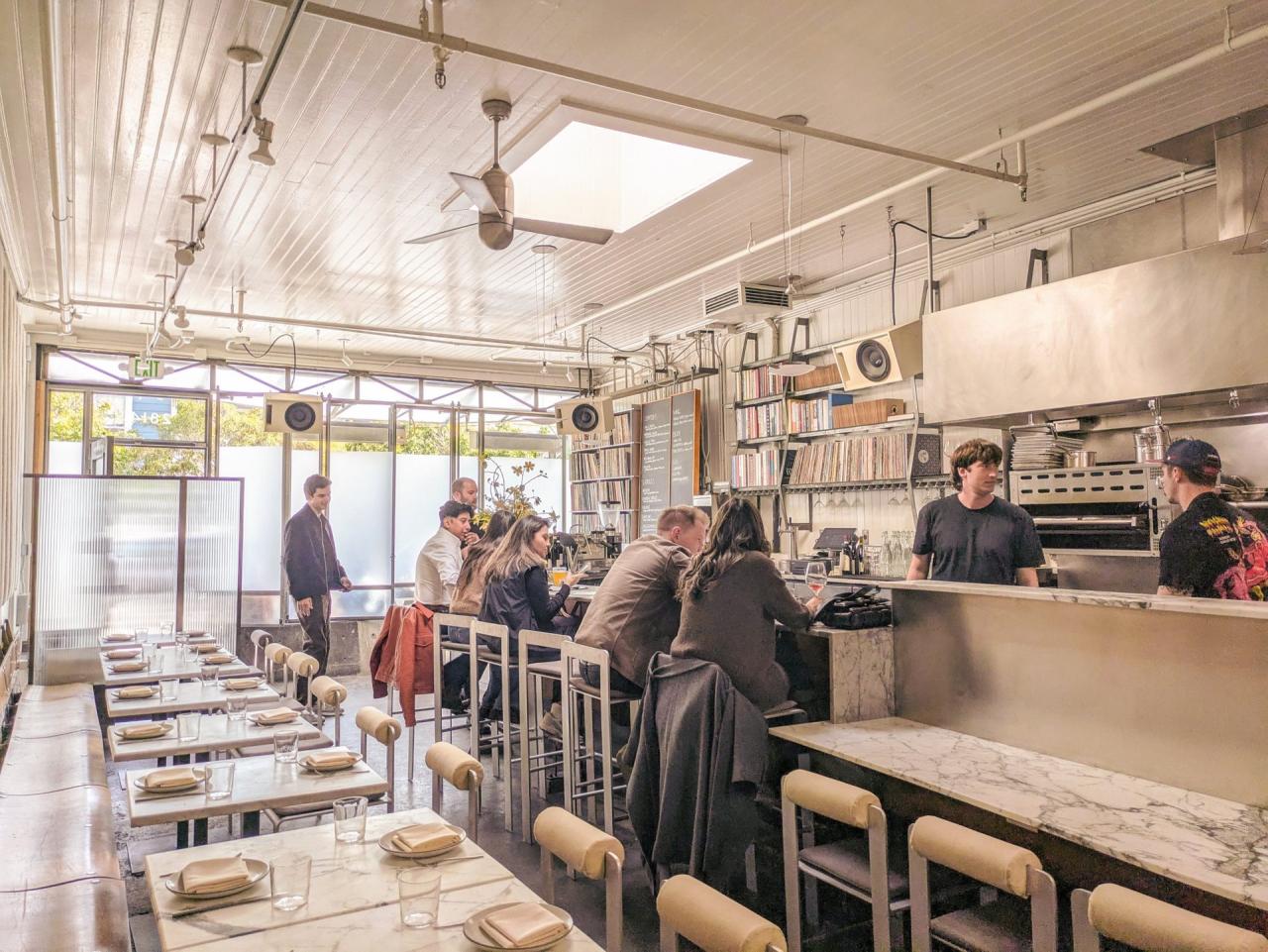 Interiorul Side A San Francisco cu standul de DJ din aluminiu lustruit, rafturile de viniluri si tejgheaua de marmura originala