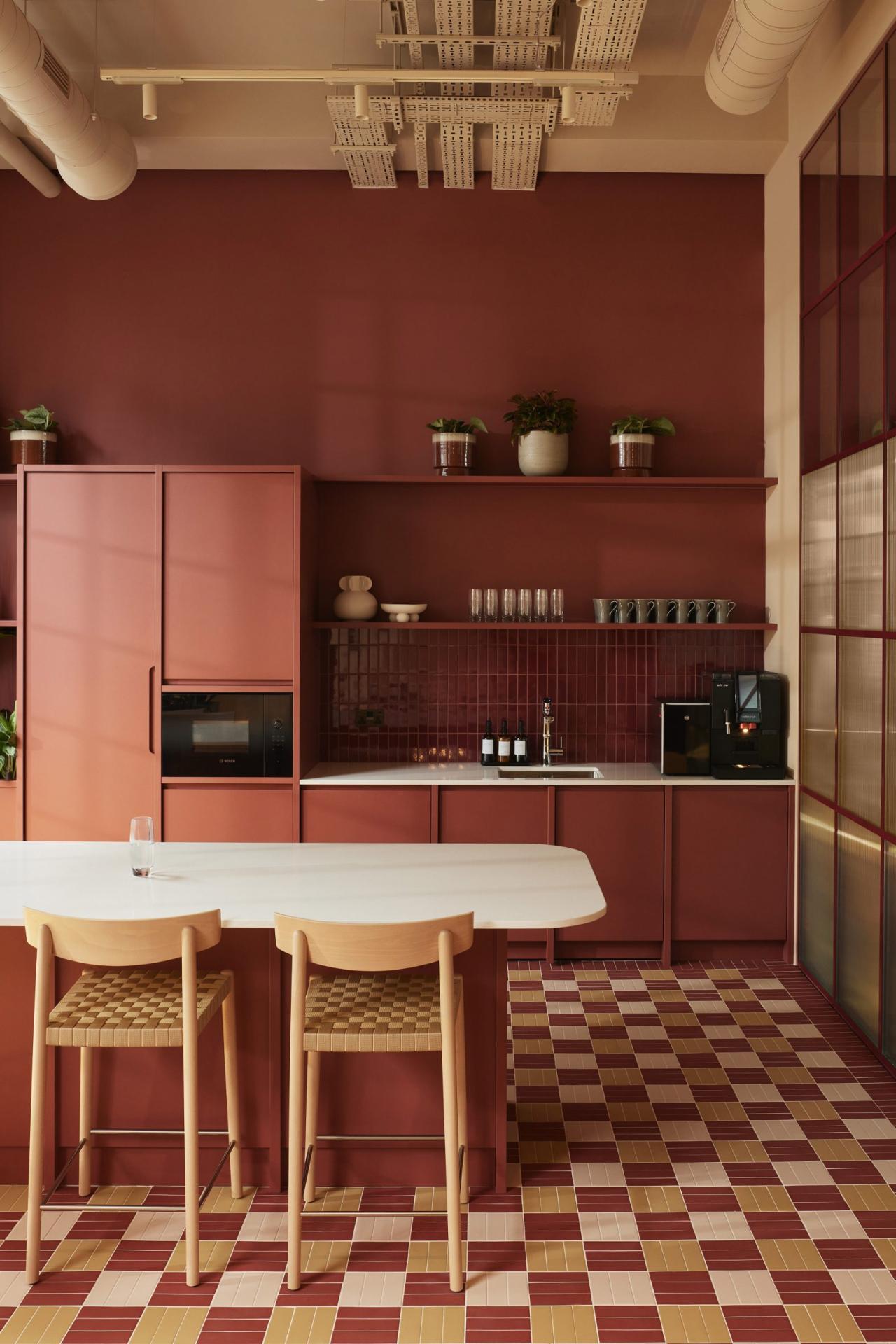 Bucataria biroului cu mobilier rosu-tera cotta si pardoseala cu mozaic