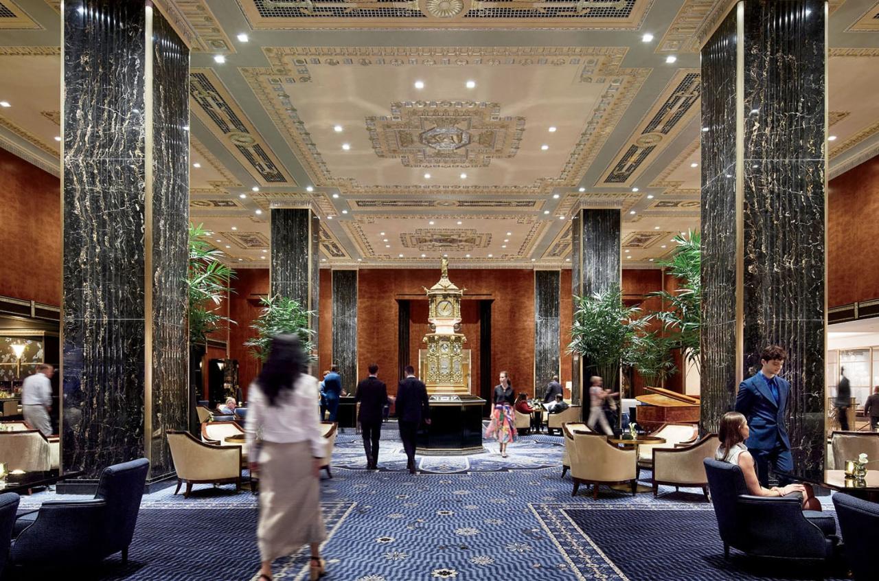 Lobby-ul Waldorf Astoria cu ceasul iconic din 1893, coloane de marmura si covoare albastre
