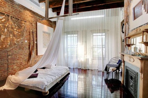 Loft-style-bedroom-with-high-ceiling-wooden-beams-and-low-slung-decor