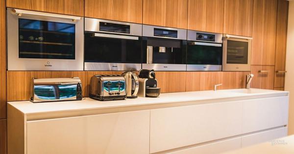 Warm-wooden-surfaces-combined-with-sleek-white-kitchen-counter
