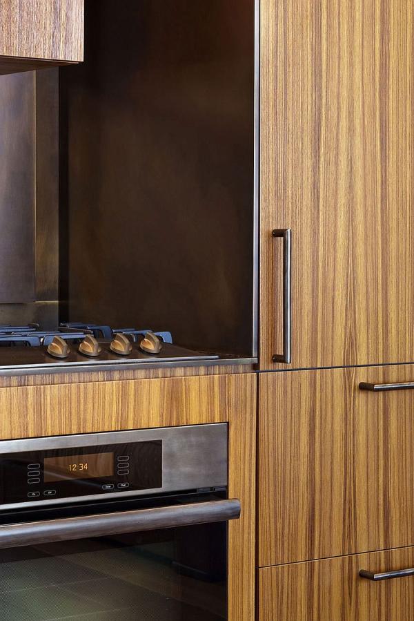 Wooden-shelves-and-a-sleek-kitchen-workstation-bring-elegance-to-the-chic-apartment